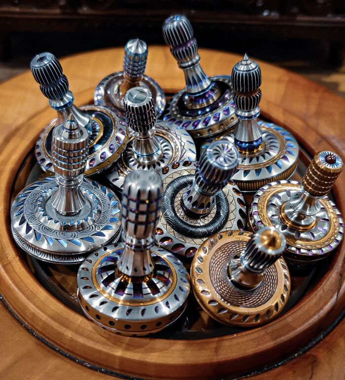 Intricately designed spinning tops collection displayed in a wooden bowl, showcasing a unique obsession turned hobby.