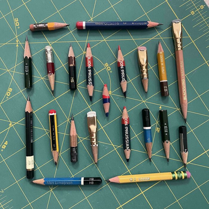 Collection of uniquely sharpened and worn pencils arranged on a green cutting mat, showcasing an obsession growing into a collection.