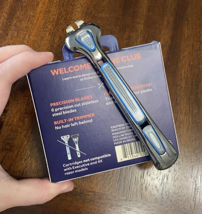 Hand holding a razor with a missing blade on its packaging, showing a disappointing shopping fail example.