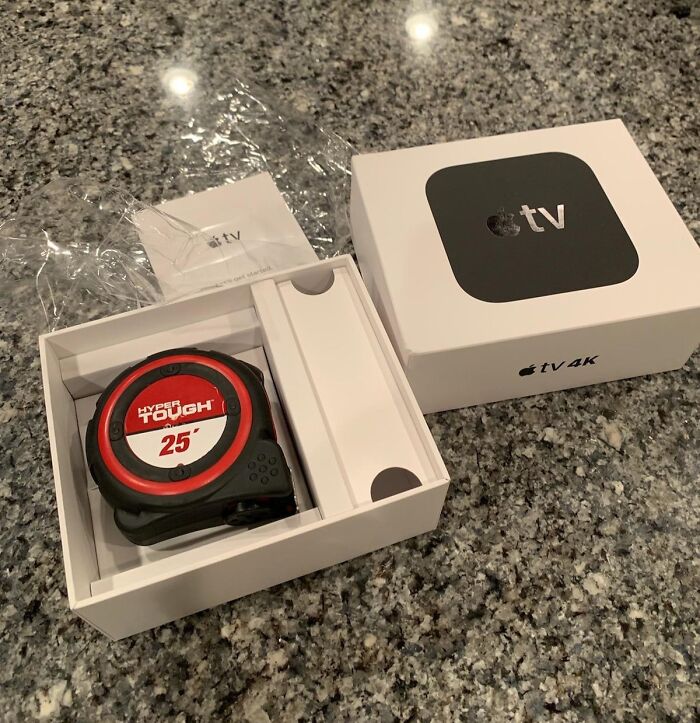 Opened Apple TV 4K box revealing a tape measure inside, illustrating disappointing shopping fails causing trust issues.