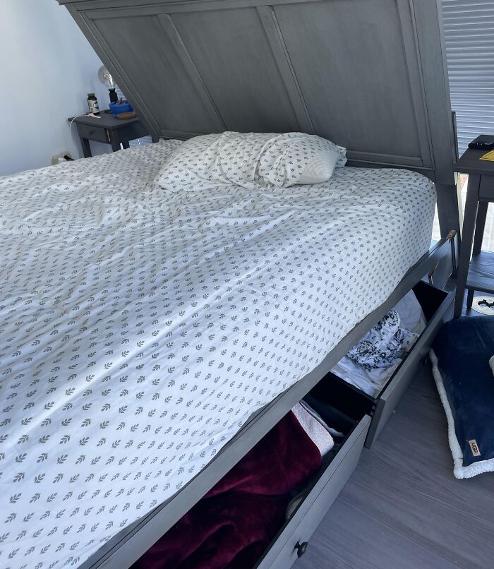 Bed with storage drawers open underneath, showing disappointing shopping fails causing trust issues with furniture design.