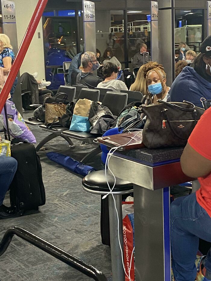 People wearing masks and waiting in an airport seating area, illustrating entitled Karens missing a sense of shame.