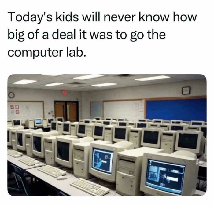 Rows of vintage 90s computer lab desktops in a classroom, evoking nostalgic memories of kids today will never know.