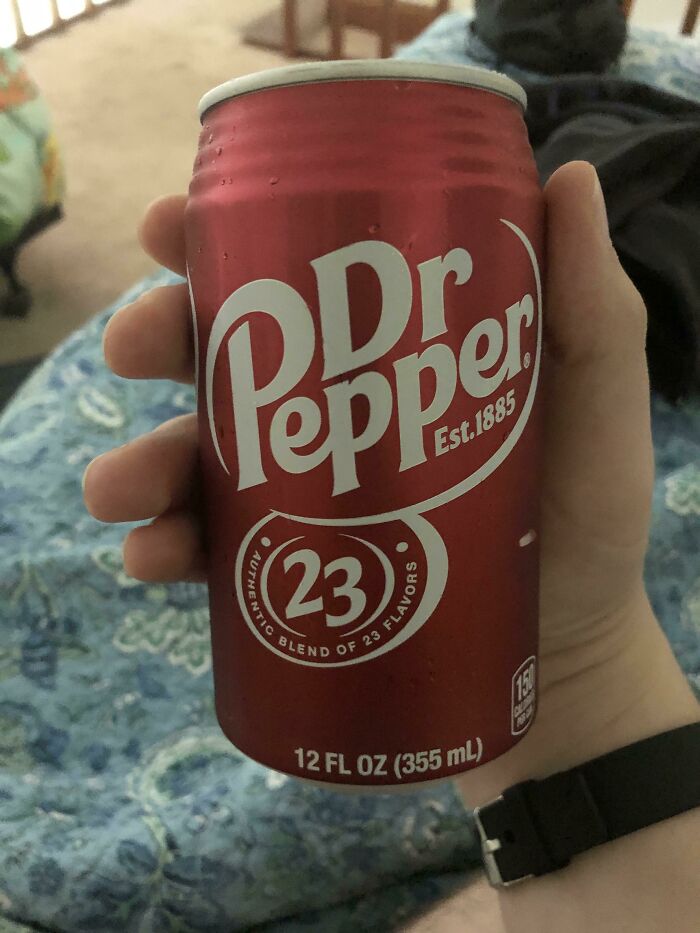 Hand holding a Dr Pepper can, representing one of the weird and unhinged family traditions involving unique beverages.