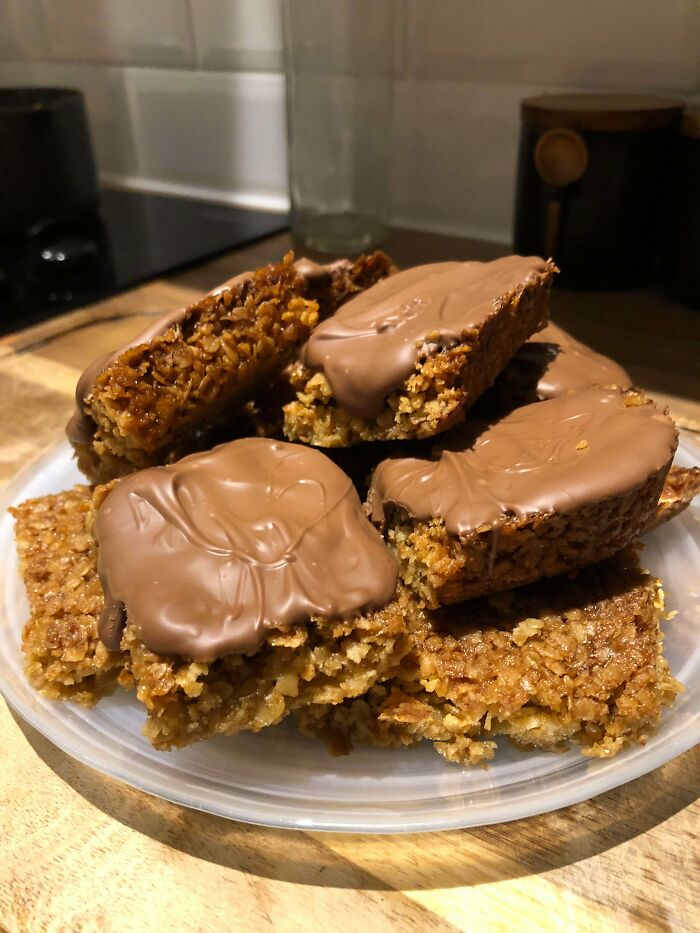 Plate of homemade granola bars topped with melted chocolate representing weird family traditions and treats.