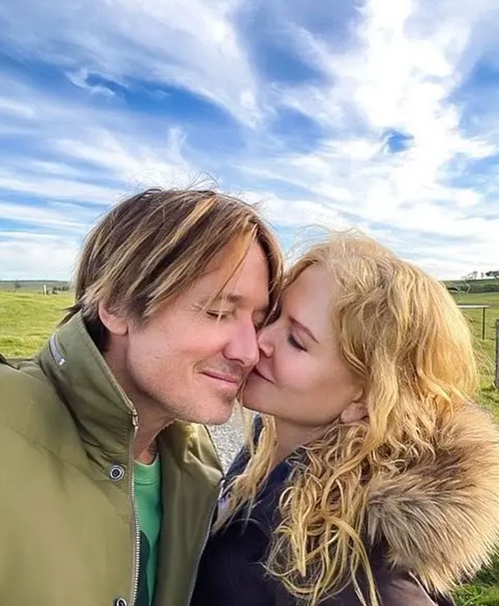 Nicole Kidman and Keith Urban sharing a tender moment outdoors under a bright sky, highlighting their relationship.