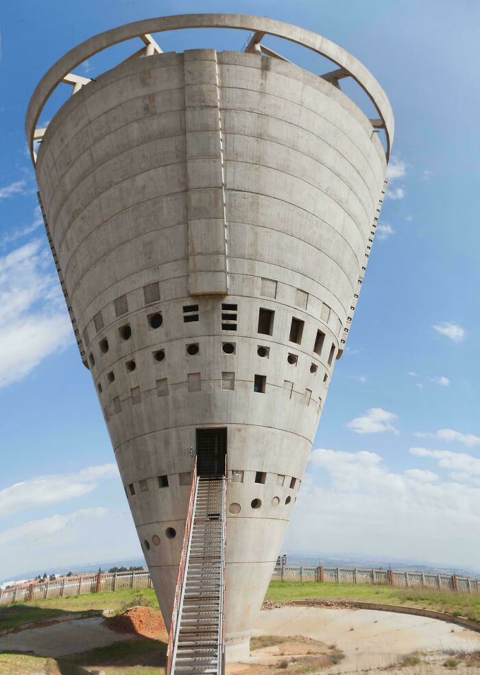 A massive, inverted conical concrete structure with a circular top, resembling an evil mastermind's lair.