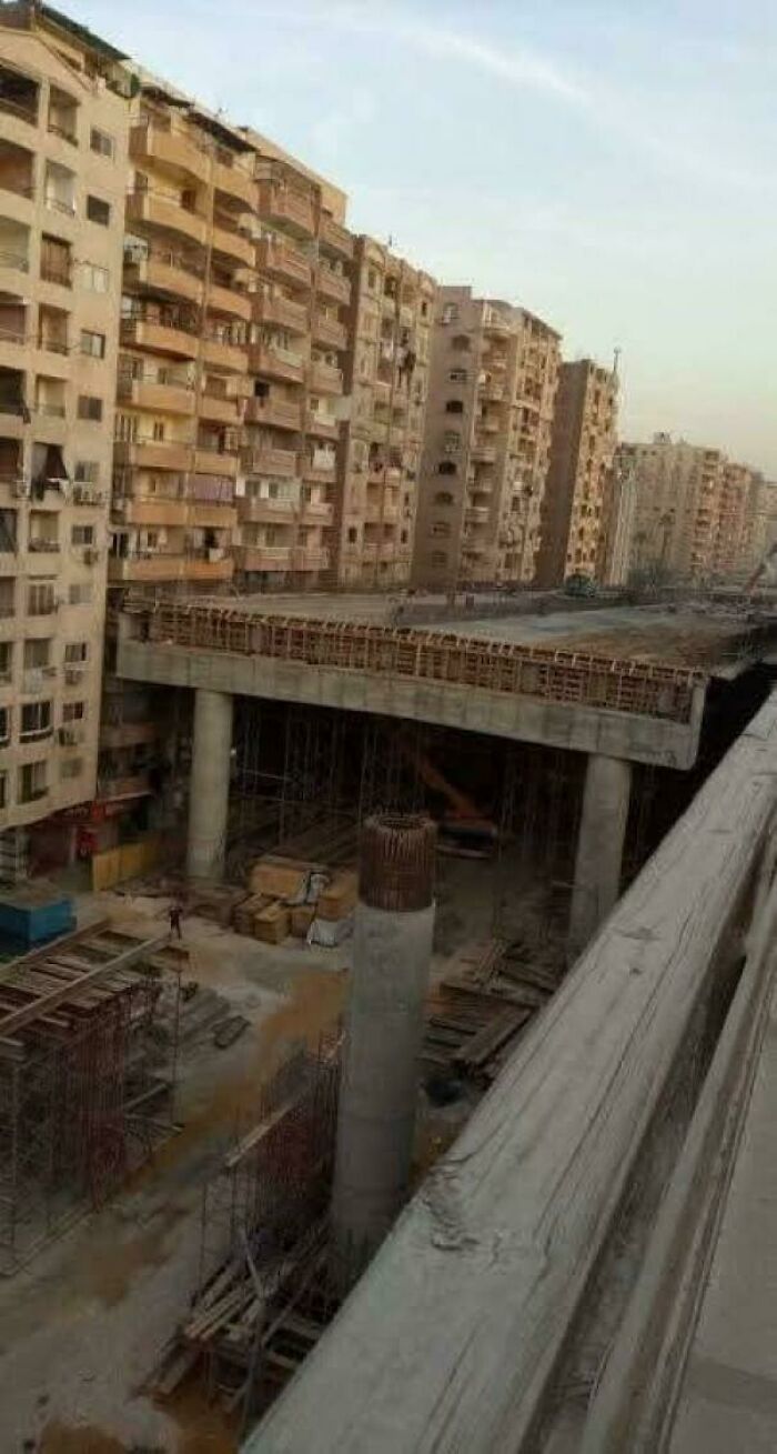 Urban hell construction site among crowded residential buildings with unfinished concrete structure