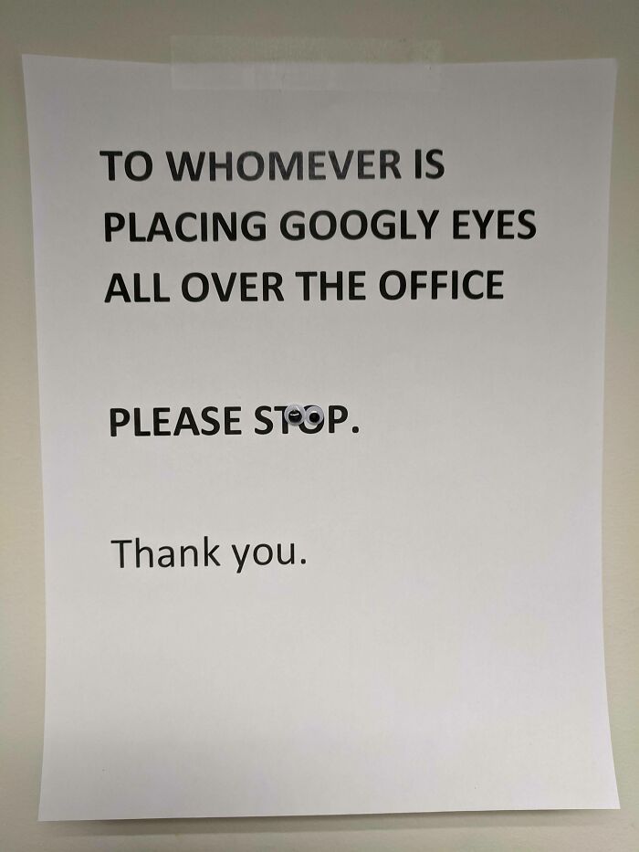 Printed office sign asking to stop placing googly eyes, with googly eyes stuck on the word stop, mild vandalism humor.