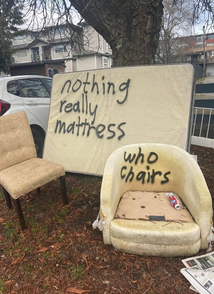 Old furniture with humorous graffiti vandalism, including a mattress and chairs with witty spray-painted messages.