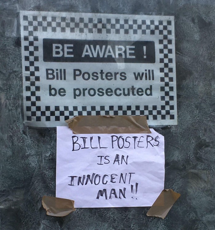 Sign warns bill posters of prosecution with a taped note humorously defending them, showing mild vandalism and street humor.