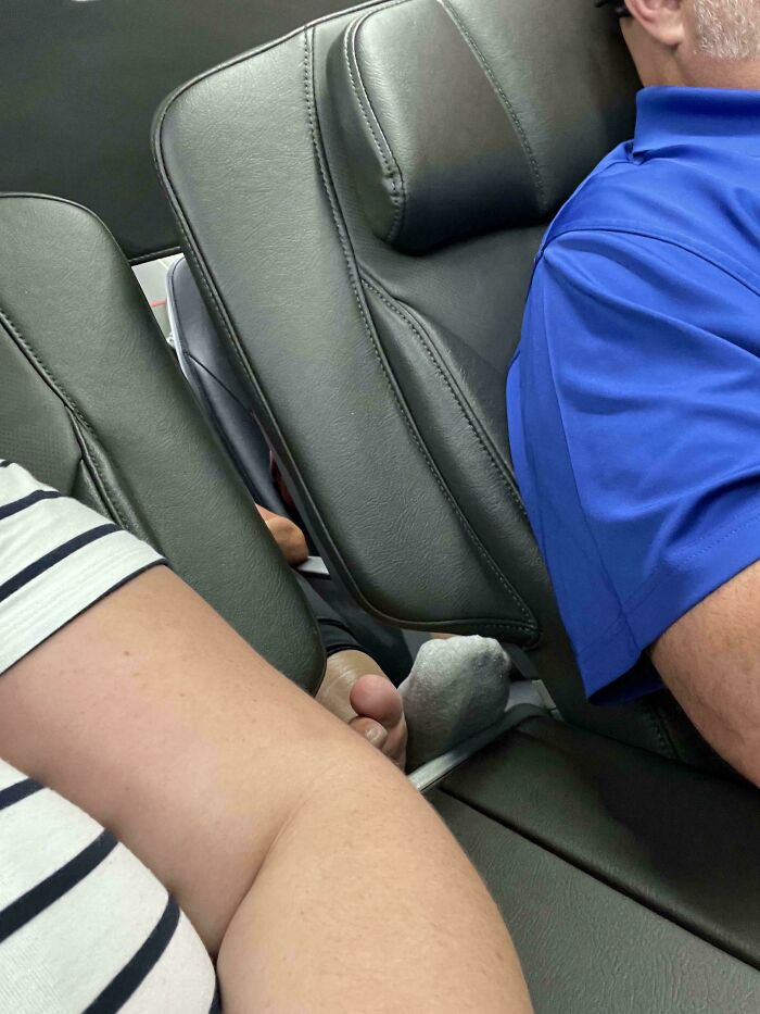 Passenger with socked foot resting on airplane seat between entitled Karens ignoring personal space rules.