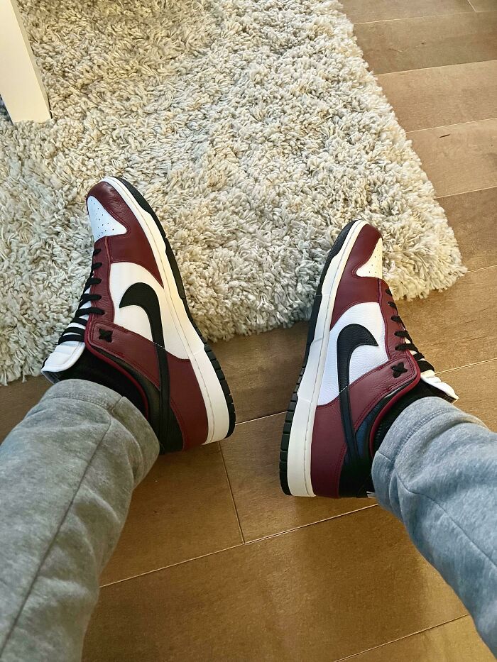 Red black and white Nike sneakers on hardwood floor and beige rug, showcasing American things people believe only exist in movies.