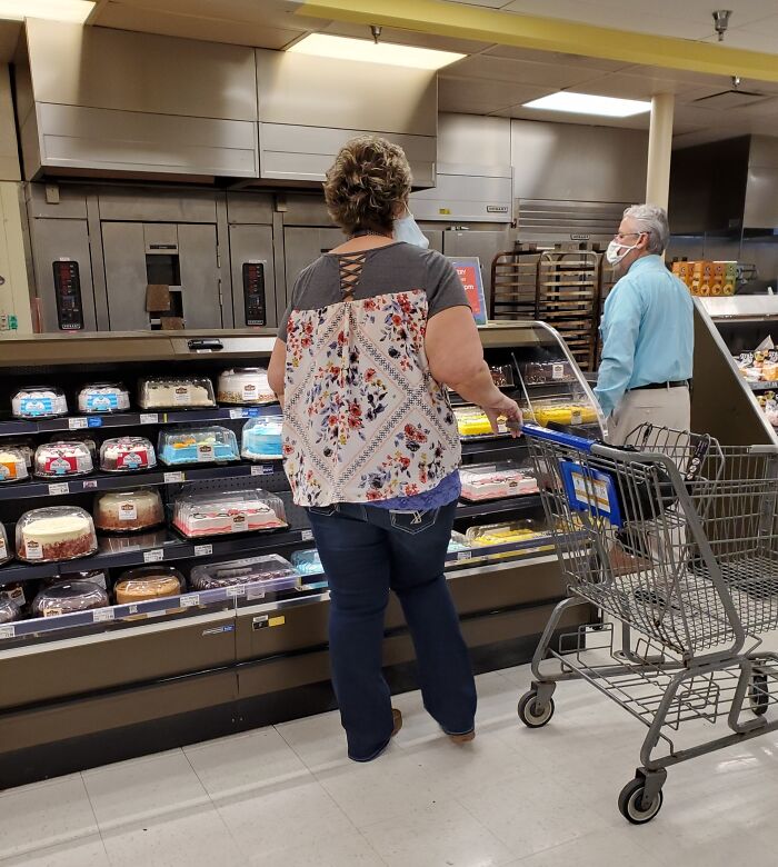 Woman shopping for cakes in a grocery store, representing entitled Karens missing a sense of shame in public settings.