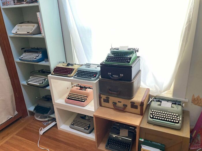 Vintage typewriter collection displayed on shelves and suitcases in a sunlit room showing unique obsessions.