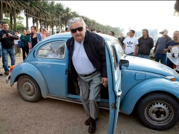 Amazing photo of a man stepping out of a classic blue car, possibly a Volkswagen Beetle, an image that might brighten your day.