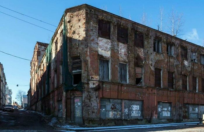 Eerie urban hell with dilapidated abandoned building and broken windows under blue sky