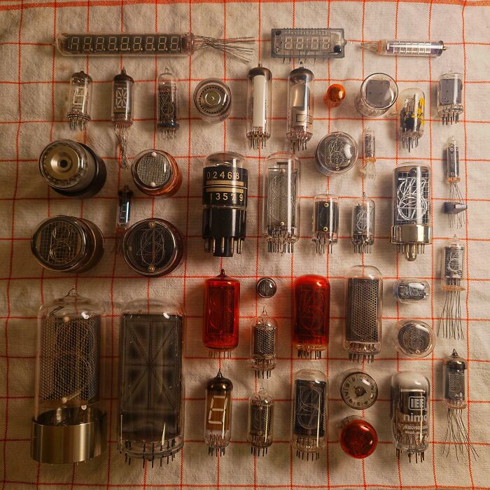 Collection of vintage electronic tubes and display components arranged on a checkered cloth, showing unique obsession collections