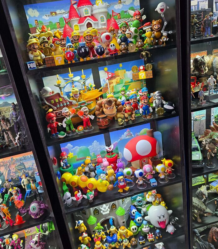 Display case filled with an extensive collection of Mario and Nintendo character figurines and toys.