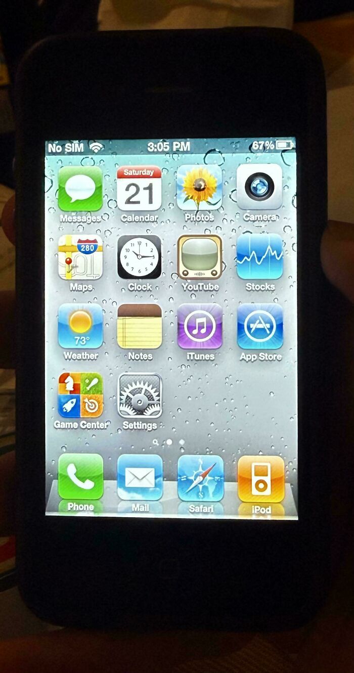 Vintage iPhone screen showing classic 2010s apps like YouTube, iTunes, Safari, and Messages on a black device.