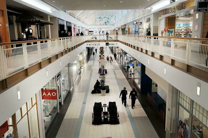 Indoor mall corridor with shoppers walking and store signs visible, capturing the nostalgic atmosphere of the 2010s era.