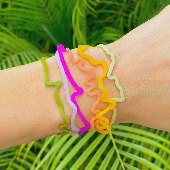 Colorful wavy silicone bracelets on wrist, evoking nostalgic 2010s fashion trends and retro style accessories.