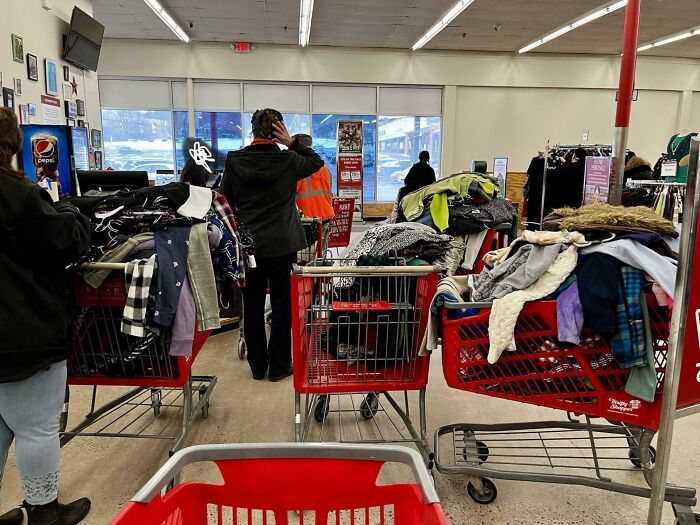 People shopping with carts full of clothes piled high, illustrating entitled Karens lacking a sense of shame.