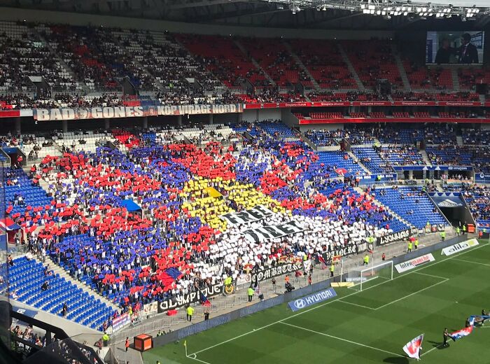 Crowd holding colored cards forming a pattern in stadium stands, illustrating moments people forgot what could go wrong disasters.