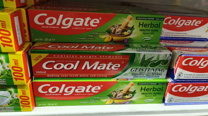 Colgate and Cool Mate toothpaste boxes on store shelf showing shameless designer copies of famous brands.