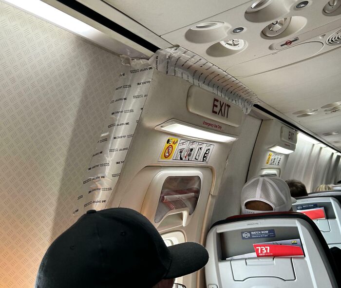 Airplane emergency exit temporarily fixed with duct tape in a technically working but unconventional solution.