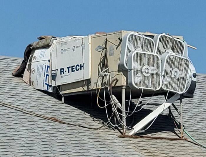 Roof air conditioning unit rigged with multiple box fans and insulation material, a technically works but unconventional solution.
