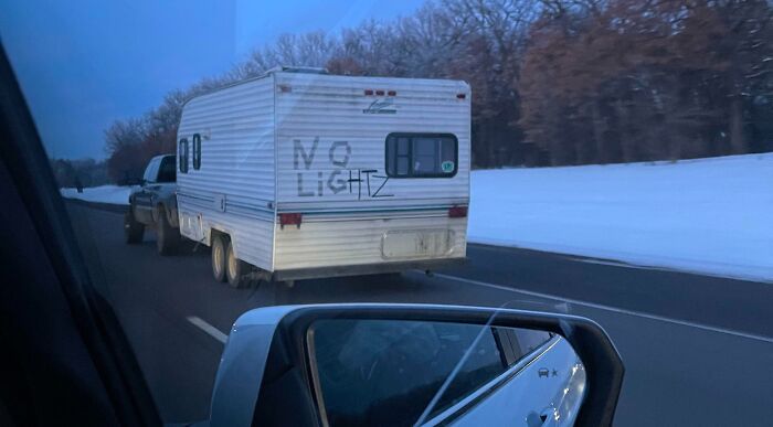 Trailer with no working brake lights has a handwritten sign that says no lightz, showing a hilariously dumb solution to a problem.