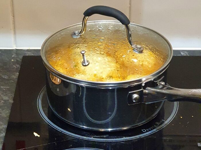 Pot with a s***w used as a steam vent in the lid, showcasing a hilariously dumb but technically works cooking solution.