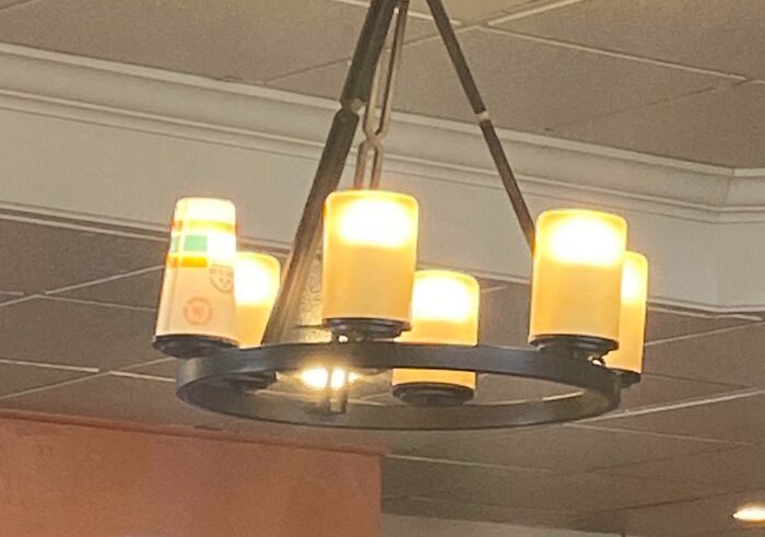 Chandelier made using upside-down plastic cups as light covers in a technically works DIY solution.