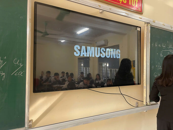 Classroom TV screen showing a shameless copy of a famous brand logo spelled as Samusong.
