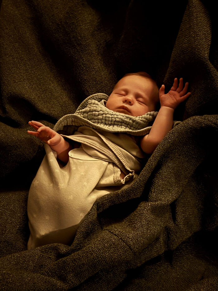 A swaddled sleeping baby in a warm-toned, painterly Accidental Renaissance portrait