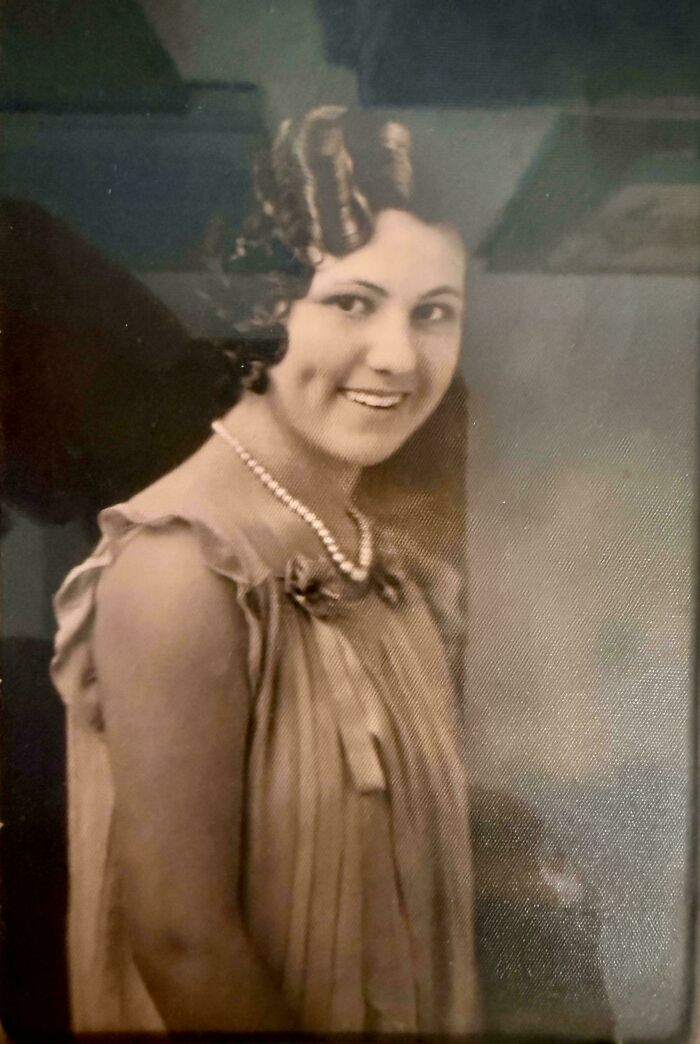 Candid old photos: A smiling woman with a pearl necklace and styled hair.