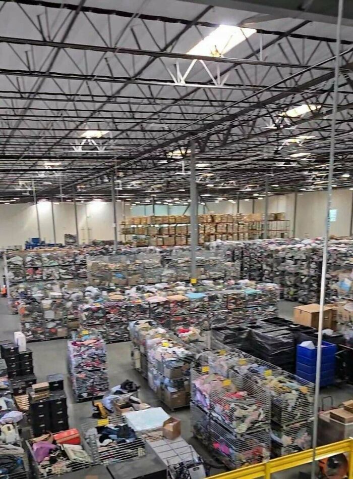 An overhead view of a massive warehouse filled with countless bins of clothes, showing extensive consumerism.