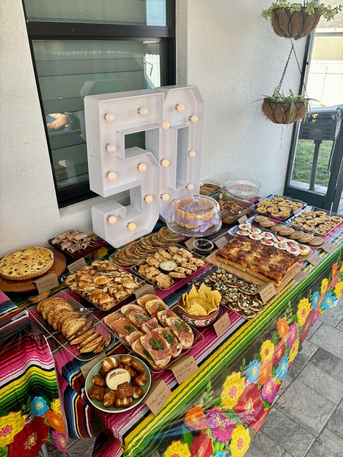 Table with assorted desserts and a large 50 light decoration for celebration