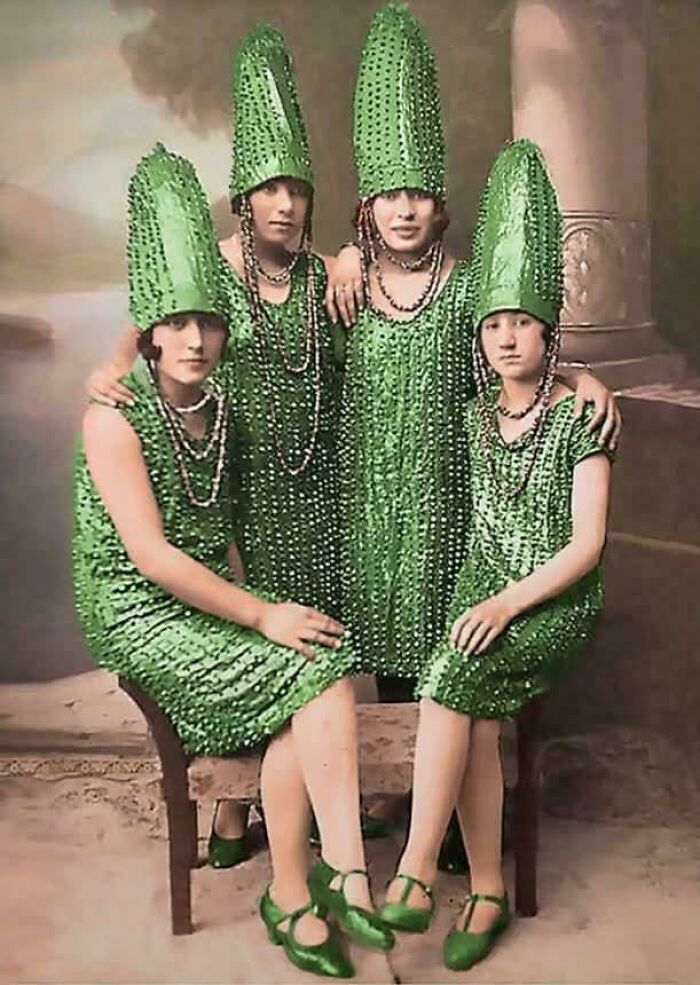 Four women dressed in bizarre green costumes and hats, showcasing strange throwback moments unlikely in 2026.