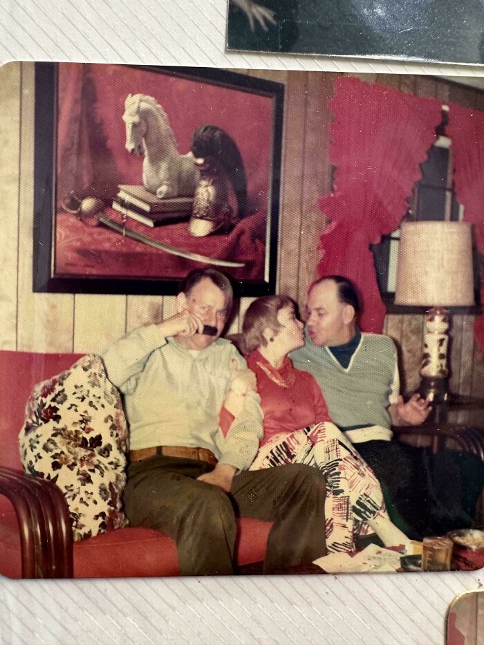 Three people sitting on a vintage couch in a retro room, capturing bizarre throwback moments impossible in 2026.