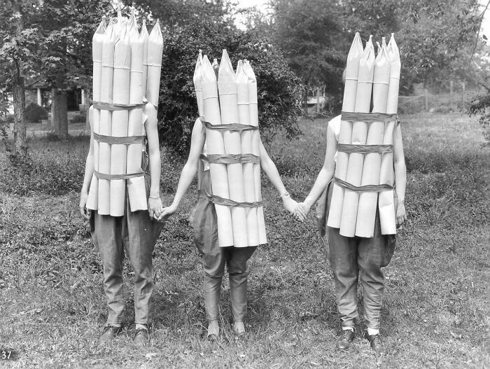 Three people dressed in bizarre historical costumes resembling explosives in a bizarre throwback moment.