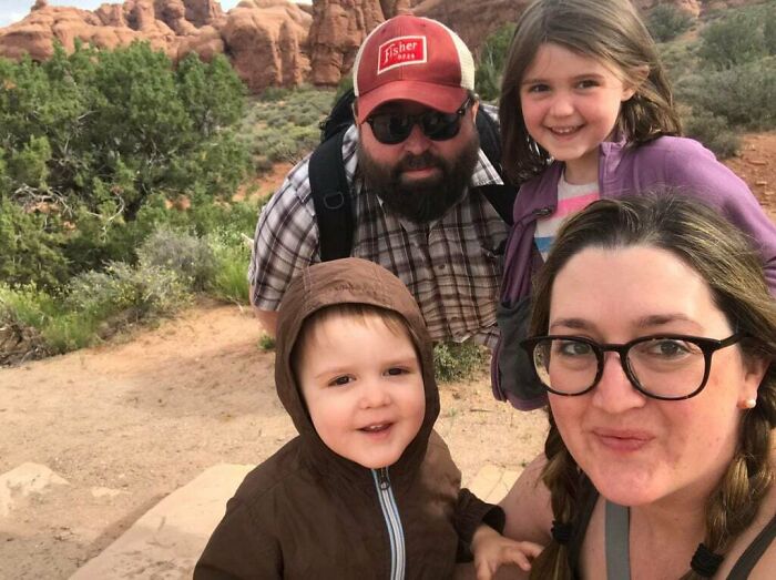 Family hiking outdoors with scenic rocky background, featured in unedited photos that might mess with your tired brain.
