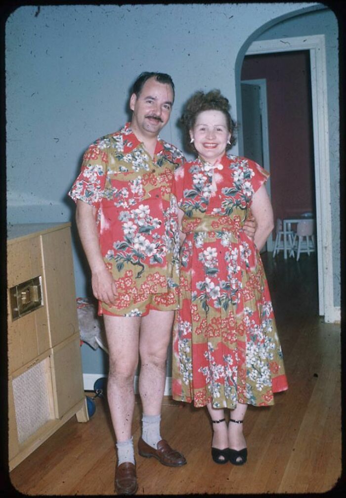 Couple in matching vintage floral outfits posing indoors in a bizarre throwback moment unlikely to happen in 2026.