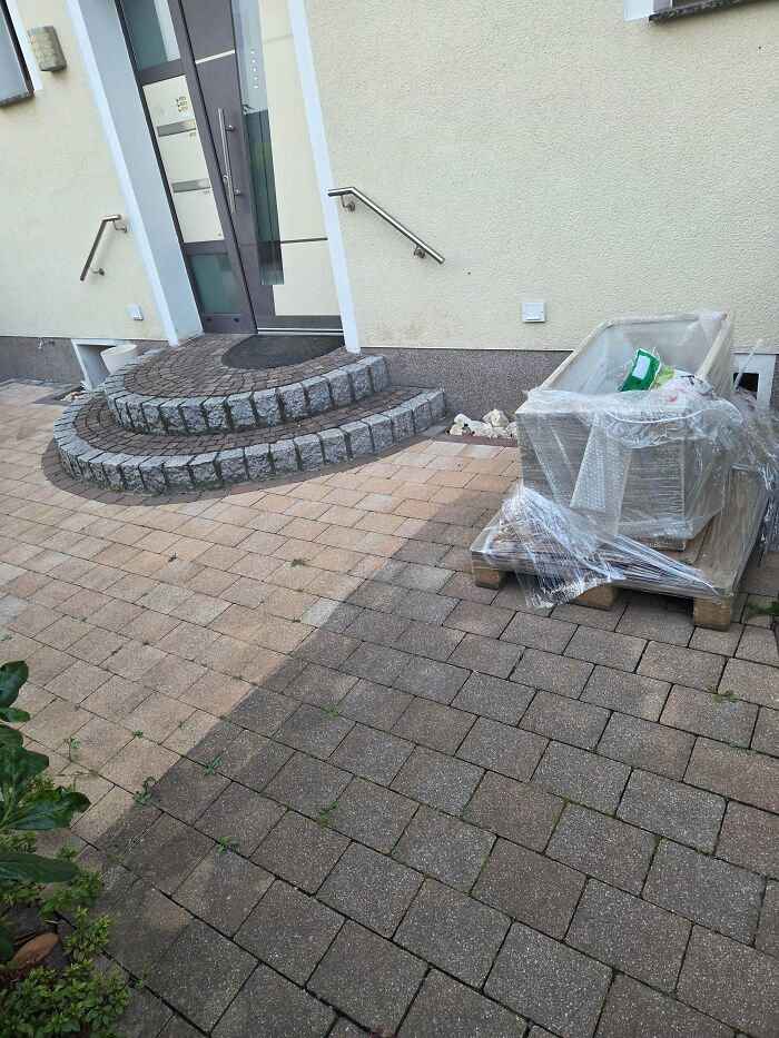 Stone steps and a paved patio outside a house showing a wrapped plastic bin, illustrating neighbors that would make you move away.