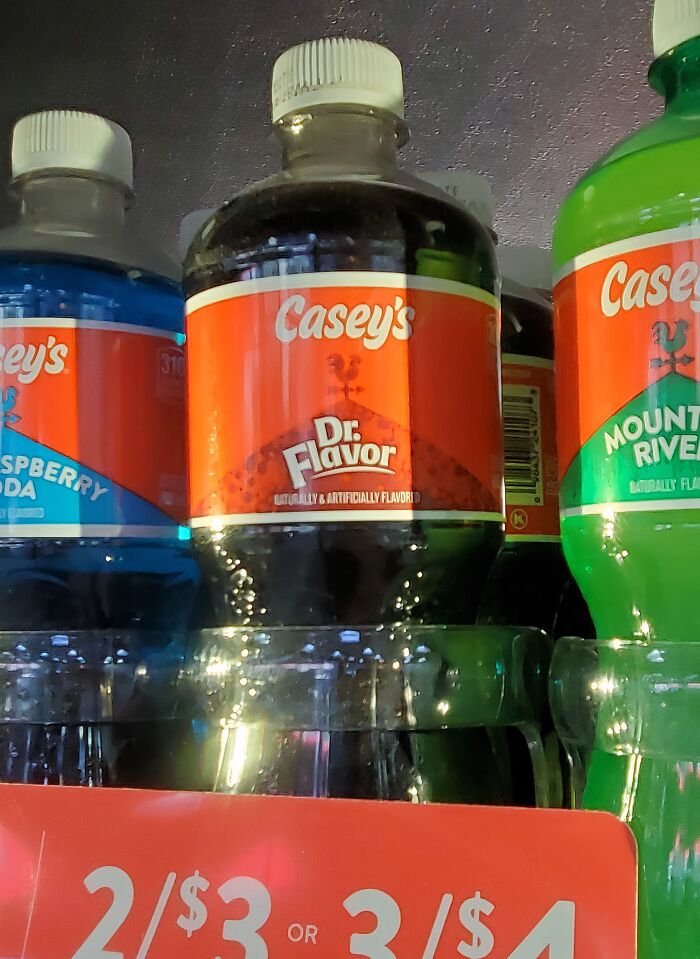 Bottles of soda with shamelessly copied famous brands design and labels on store shelf with price tag.