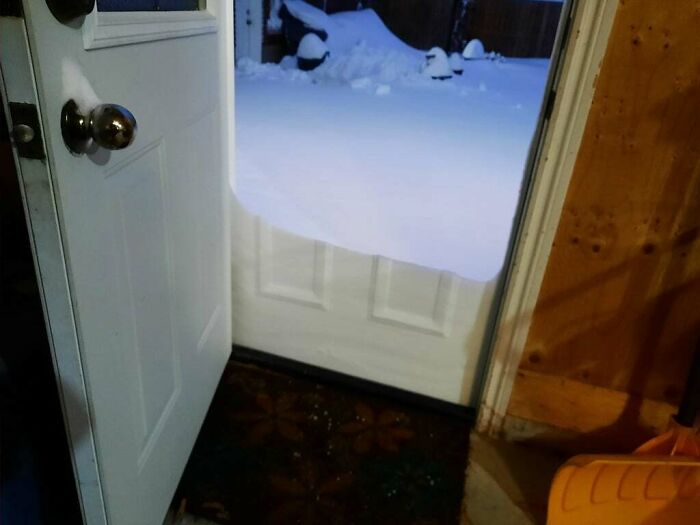 Snow piled against a door, showing unedited photo that might mess with your already tired brain with new pics of nature.