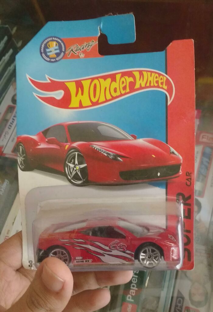 Hand holding toy car packaging labeled Wonder Wheel, showing a red car design copying famous brand style, shameless brand copy example.