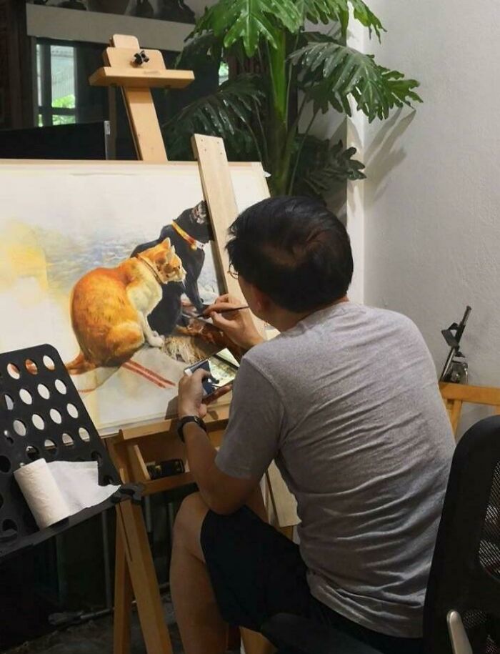 Man painting a detailed portrait of pets, showcasing the bond between dads and the pets they never wanted but now love.