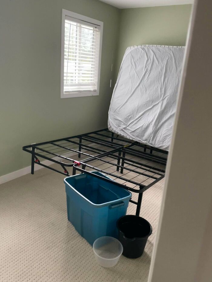Empty bedroom with mattress on metal frame leaning against wall and buckets on floor, illustrating home buyer regrets.